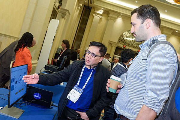 An exhibitor showcases a product to a potential client at the MSP Summit 2022